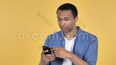 青年非洲男子智能<strong>手机网</strong>上购物，黄色背景