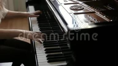 女子两只手在一架大型钢琴上弹奏<strong>古典音乐</strong>，动作缓慢