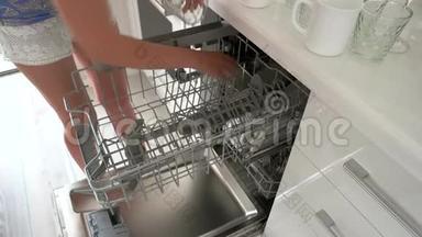 女人在家里把玻璃放进<strong>洗碗机</strong>里。