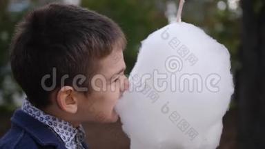 快乐的白种人少年吃棉花糖。 童年的梦想和回忆。 4k. 慢动作