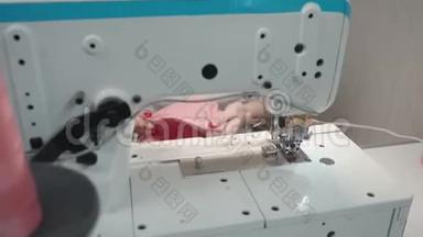 裁缝女人在电动机器上缝制粉红色衣服的视频