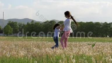 暑假快乐。 两个小妹妹在户外玩得很开心，手<strong>牵着</strong>手在城市公园的蒲公英草地上盘旋。 一个