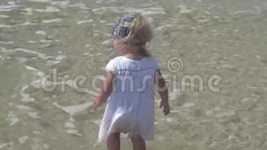 一个孩子站在海水里。 穿着白色连衣裙的小女孩在海水中散步。 愤怒的孩子。