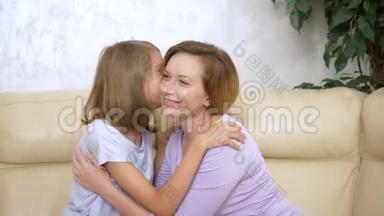家庭信任的概念，幸福的女儿<strong>悄悄</strong>地向坐在客厅沙发上的母亲一个秘密