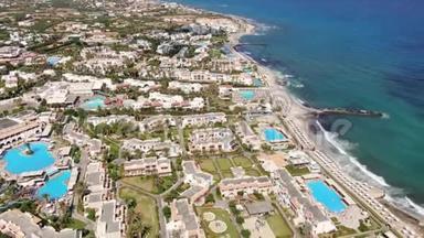 希腊著名历史上著名的克里特岛上赫森索斯附近的Anissaras海岸线的无人机空中飞行，有酒店游泳池和海滩