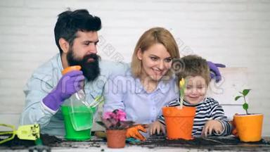 园艺的概念。 家庭在游戏形式种植和<strong>浇水</strong>。 一个小<strong>男孩</strong>和他的父母给花<strong>浇水</strong>。