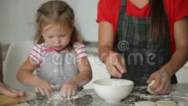 年轻的父母正在学习他们女儿`烹饪。 他们展示了所有的烹饪过程。