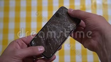智能手机的概念。手持手机的男人手的俯视图，手机显示屏破裂。破裂、破碎的lcd touc