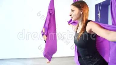 空中瑜伽课。年轻女子在吊床上练习瑜伽。