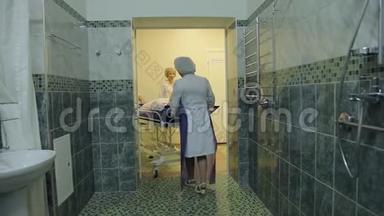 三名女护士将一名久坐不动的病人送到专门的房间去洗。 4K