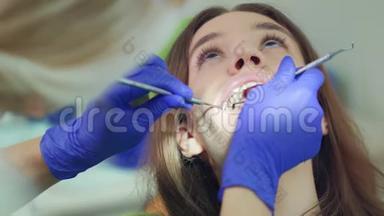 女人张开嘴的脸。 牙科医生检查病人牙齿