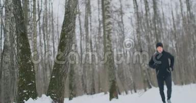 一个年轻人在冬天的森林里晨跑，累了，停下来休息，继续跑。 他恢复了<strong>体力</strong>