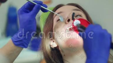 牙科手术的女病人。 牙科聚合灯牙科工作
