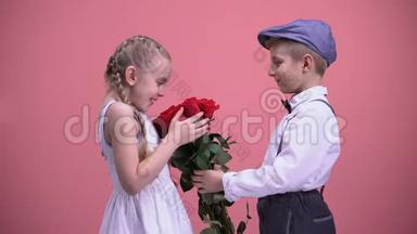 <strong>小绅士</strong>男孩向年轻女士献上玫瑰花束，情人节