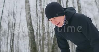 一个<strong>年轻人</strong>在冬天的森林里晨跑，<strong>累了</strong>，停下来休息，继续跑。 他恢复了体力