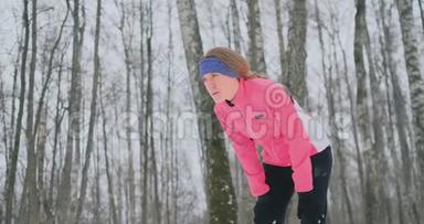 一个年轻女子在冬林里晨跑时累了，停下来喘口气。他恢复了<strong>体力</strong>