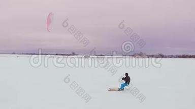 冬天在滑雪板或滑雪板上风筝。 在风中在冰上滑冰。 美丽的彩帆。