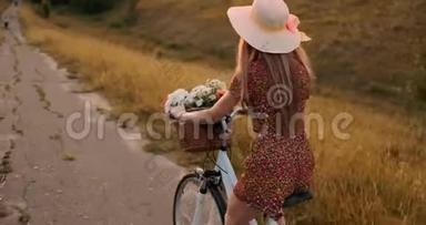 快乐的女孩带着一束花，骑着一辆自行车戴着帽子，穿着一件夏天的短裙。