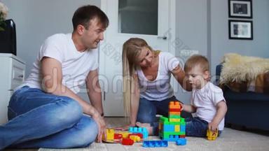 幸福的家庭爸爸妈妈和宝宝在他们明亮的客厅里<strong>玩乐</strong>高。 慢镜头拍摄幸福家庭