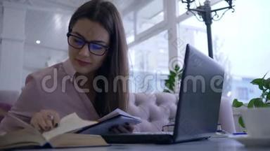 在线教育，戴眼镜的学生女孩在现代上网本上的视频聊天中在笔记本上写笔记