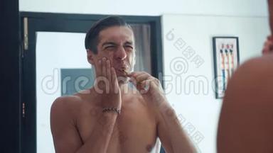 男人在浴室刷牙停止的肖像，因为<strong>牙齿</strong>疼痛。 牙科<strong>问题</strong>