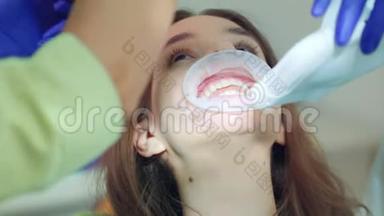 牙科诊所牙齿美白手术病人。 医生打开灯