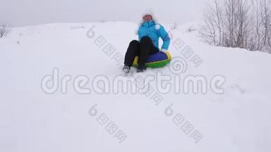 冬天，女孩骑着雪碟从高山上飞过雪地，快乐地笑着。 快乐的女人在哭泣
