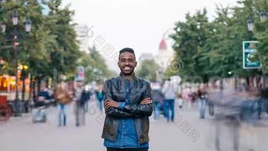 美国黑人学生看着摄像机，微笑着站在街上的英<strong>俊男</strong>子的照片