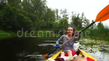 一个年轻的女孩在河上的皮划艇上用桨<strong>努力</strong>工作