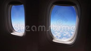 飞机飞行。 一架飞机的机翼在云层上方飞行，天空是夕阳。 从飞机的窗口看