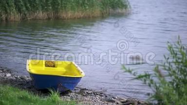 五彩缤纷的小船停泊在湖边的石岸上，在夏天阳光明媚的日子里。 艺术。 在湖边划船