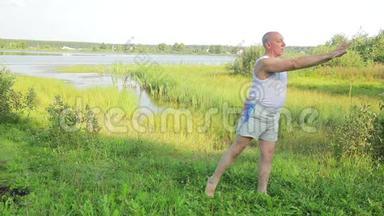 一位中年男子早上在湖边做瑜伽和呼吸练习