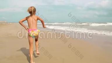两个迷人的小女孩沿着海岸沿着大海奔跑。 节日快乐的孩子们