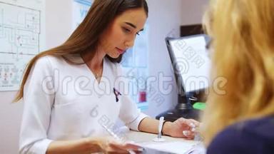 女牙医看病人的医学书，书上是坐在对面的一位妇女。看牙医
