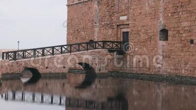 帕福斯城的历史城堡。 砖堡部分侧视.. 木制城堡桥展示在水中。 入口美景