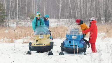冬天。 一家人穿着五颜六色的夹克，骑着雪地摩托，准备乘车