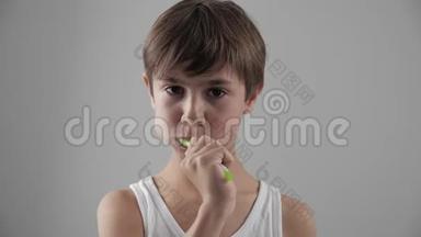 12岁的男孩刷牙，牙疼得厉害。 牙齿问题。 蛀牙。 牙科问题