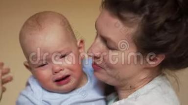 一岁的婴儿在母亲的怀里哭。 亲密的肖像，母亲`日子