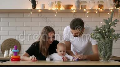 家庭、<strong>父母</strong>和人的概念-幸福的<strong>父母</strong>向婴儿展示平板电脑