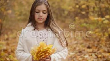 可爱的女孩捧着一束秋叶
