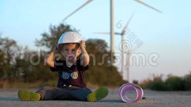 一个小男孩玩建造师头盔。 他穿上它，高兴地拍手