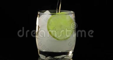 一种清爽的饮料被<strong>倒入</strong>一个装有冰块和石灰的玻璃<strong>杯中</strong>