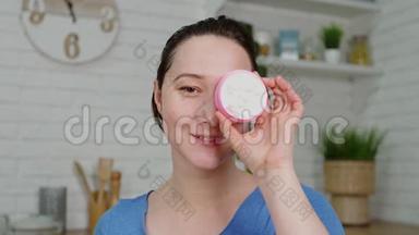 在厨房里，特写女郎微笑着摆着奶油粉色罐子