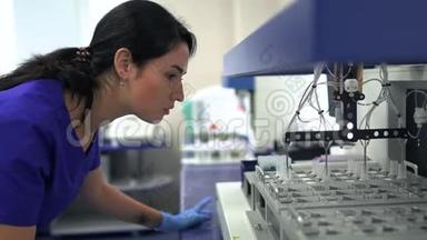 肖像年轻妇女穿蓝色制服和橡胶手套控制药物制造在实验室。 开展活动