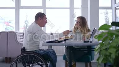 残疾学生个人学习、戴眼镜的女教师在轮椅上为残疾男子讲课