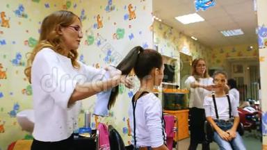 美容师和小女士。 <strong>美发</strong>沙龙里的有趣孩子。 用发胶固定马尾辫。 <strong>儿童</strong>理发店。
