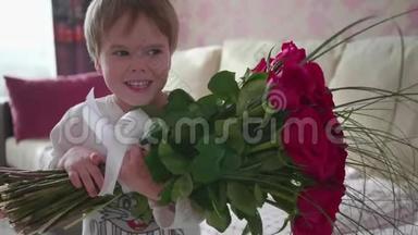 快乐的宝宝捧着一大束红玫瑰。 送给妈妈`生日礼物