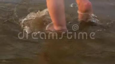 幼儿`在沙滩上踩水，快乐的孩子在水里踩脚，特写，慢动作