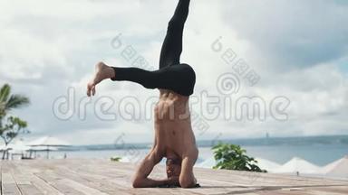 在美丽的海滩上用<strong>倒立</strong>做瑜伽运动的人。