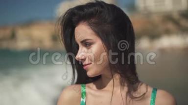 肖像可爱幸福的女孩站在大海的背景上。 一张漂亮的年轻女人的脸，长长的黑发